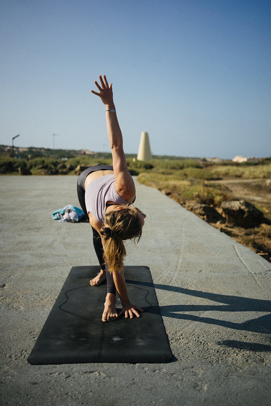 Woman in a dynamic yoga warrior pose outdoors.